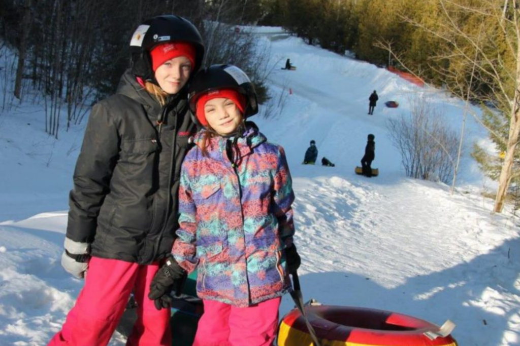 Enfants en glissade sur tubes à la Base de plein air Bon départ