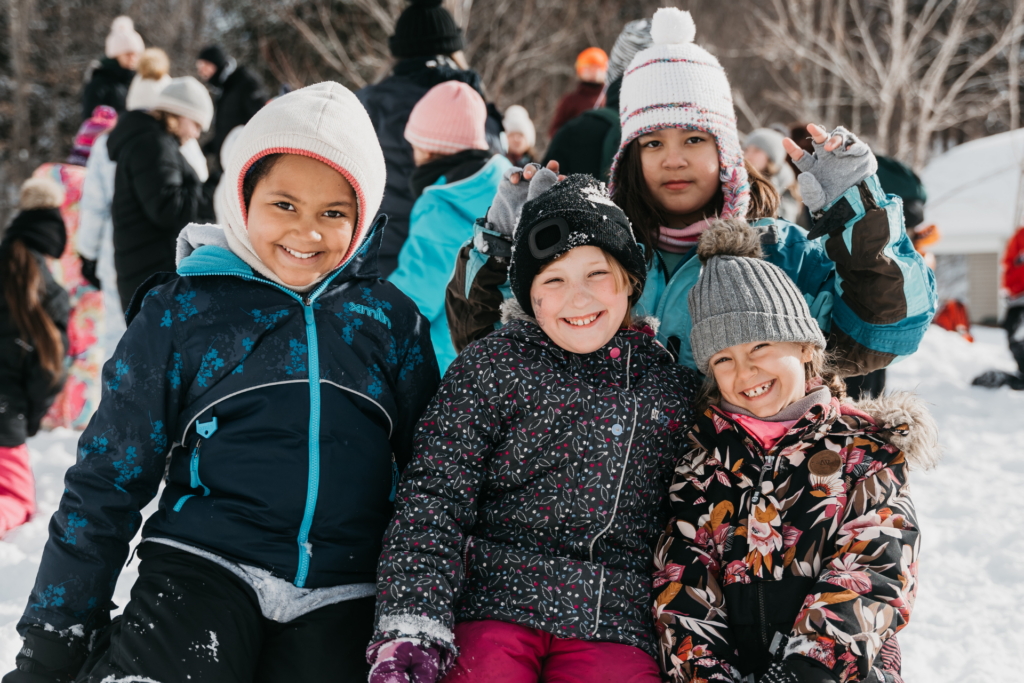 Enfants souriant dans la neige à la Base de plein air Bon départ